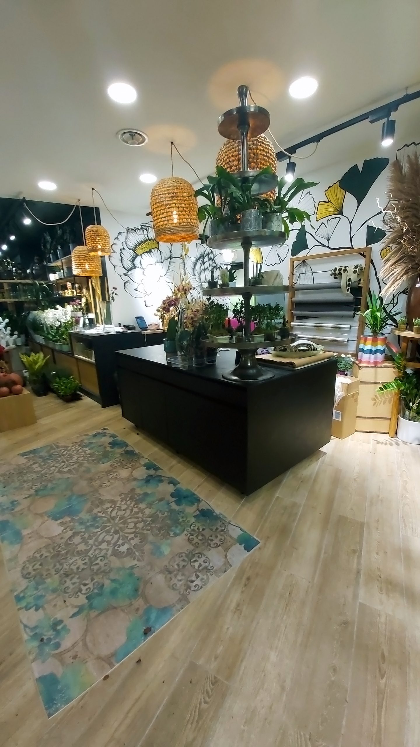 Magasin de fleuriste avec un mur blanc et des meubles noirs