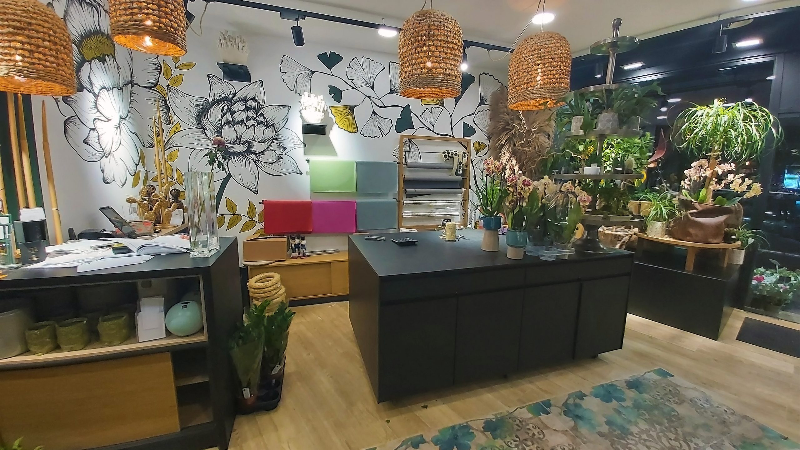 Magasin de fleuriste avec un mur blanc et des meubles noirs